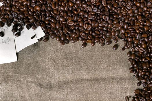 Coffee beans and sheet music on burlap background. Top view. Copy space. Still life. Mock-up. Flat lay