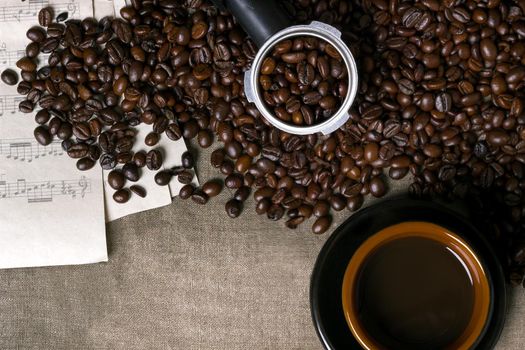 Coffee beans, sheet music and Coffee cup on a burlap background. Top view. Copy space. Still life. Mock-up. Flat lay