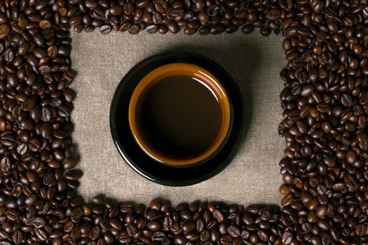 Coffee beans and Coffee cup on a burlap background. Top view. Copy space. Still life. Mock-up. Flat lay