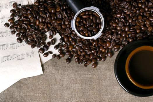 Coffee beans, sheet music and Coffee cup on a burlap background. Top view. Copy space. Still life. Mock-up. Flat lay