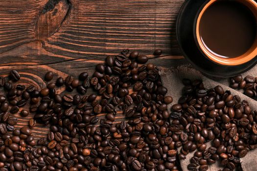 Coffee cup and beans frame on wooden table. Top view. Copy space. Still life. Mock-up. Flat lay