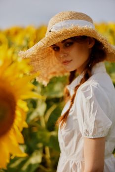 beautiful sweet girl walks through a field of sunflowers Summer time. High quality photo