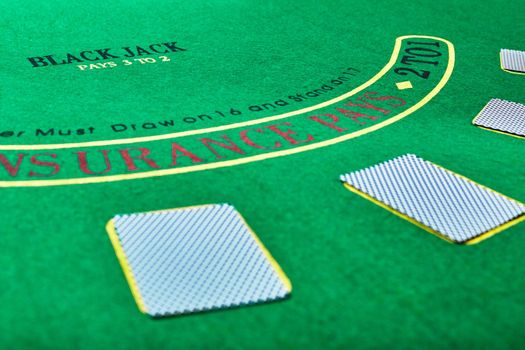 casino, gambling, poker, and entertainment concept - playing cards on green table surface