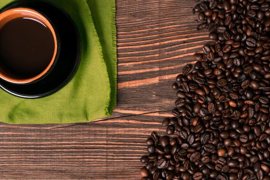 Coffee cup and coffee beans on wooden background. Top view. Still life. Copy space. Flat lay.