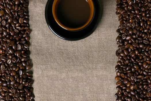 Coffee beans and Coffee cup on a burlap background. Top view. Copy space. Still life. Mock-up. Flat lay