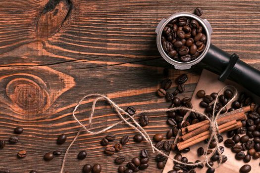 Coffee beans and cinnamon sticks on rustic wooden table, view from above with space for text. Still life. Mock-up. Flat lay