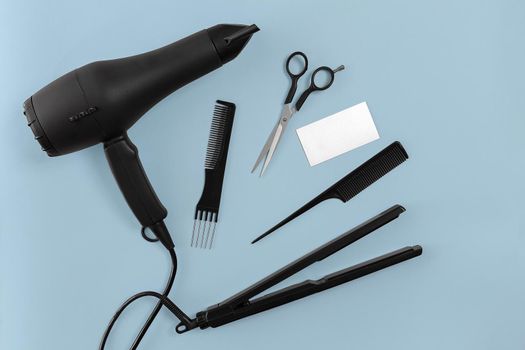 Hairdresser set with various accessories on blue background. Top view. Still life. Flat lay.