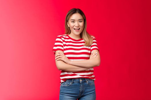 Cheerful cute asian blond girl eager waiting pool party summer vacation friend cottage, hold hands crossed chest laughing smiling enthusiastic, having fun, enjoy holidays, red background.