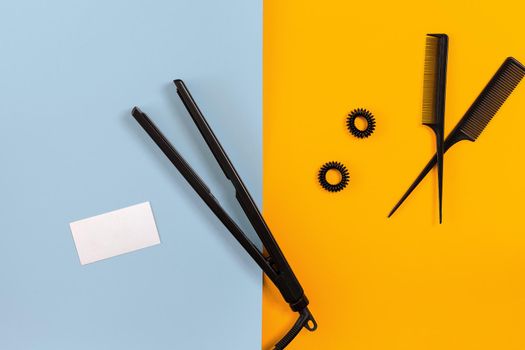 Hairdresser set with various accessories on orange and blue background. Top view. Copy space. Still life. Mock-up. Flat lay