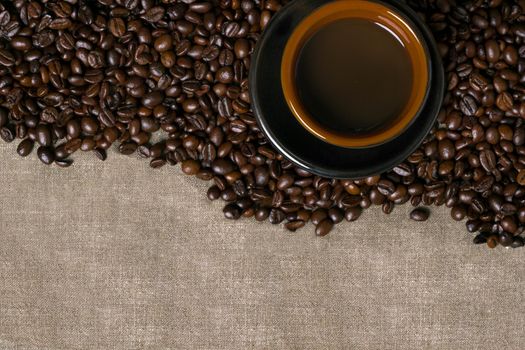 Coffee beans and Coffee cup on a burlap background. Top view. Copy space. Still life. Mock-up. Flat lay