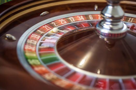 Classic casino roulette wheel with red sector twenty-one 21 and white ball. Close up details