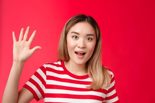 Close-up outgoing good-looking asian urban female blond hairstyle show palm high five, fifth number smiling broadly speaking make order shopping stand red background carefree and relaxed.