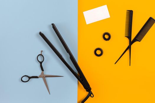 Various hair styling devices on the color blue, yellow paper background, top view. Copy space. Still life. Mock-up. Flat lay