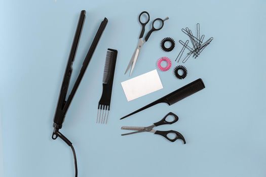 Hairdresser set with various accessories on blue background. Top view. Still life. Flat lay.