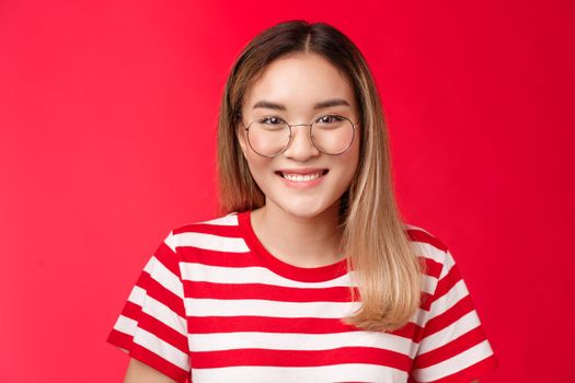 Close-up cheerful asian blond girl wear glasses smiling pleasant, give friendly toothy grin camera talking casually friends, standing happy show positive pleasant emotion, stand red background.