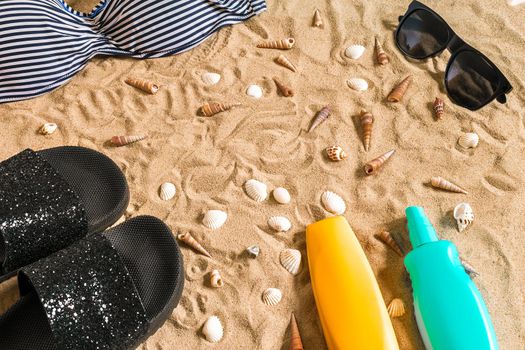 Summer bikini and accessories stylish beach set, Beach bikini summer outfit and sea sand as background, Top View, Concept. Copy space