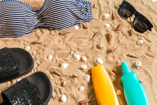 Summer bikini and accessories stylish beach set, Beach bikini summer outfit and sea sand as background, Top View, Concept. Copy space