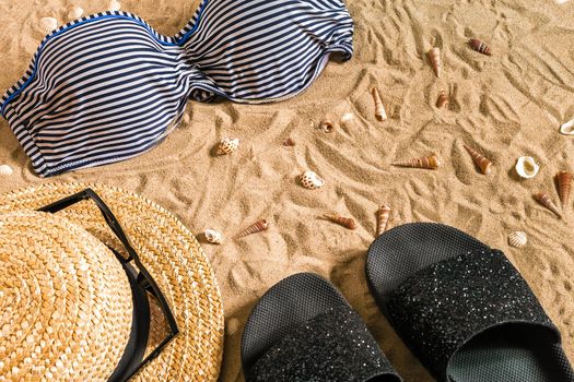 Summer bikini and accessories stylish beach set, Beach bikini summer outfit and sea sand as background, Top View, Concept. Copy space