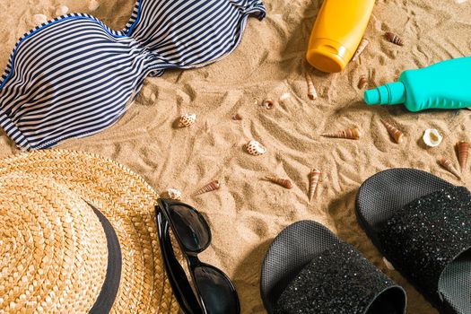 Summer bikini and accessories stylish beach set, Beach bikini summer outfit and sea sand as background, Top View, Concept. Copy space