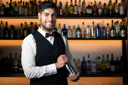 Bartender shaking cocktail shaker in cocktail bar. High quality photo