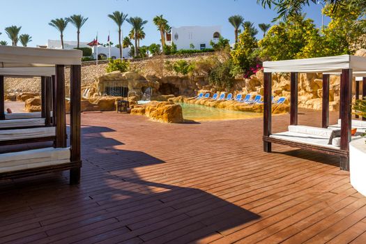 Several of luxury loungers. Exotic vacation by the hotel pool in bright sunshine, Egypt.