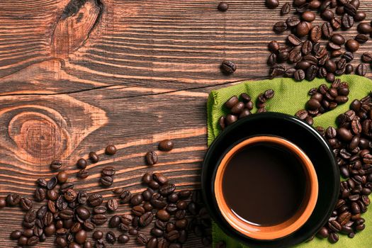 Coffee cup and beans frame on wooden table. Top view. Copy space. Still life. Mock-up. Flat lay