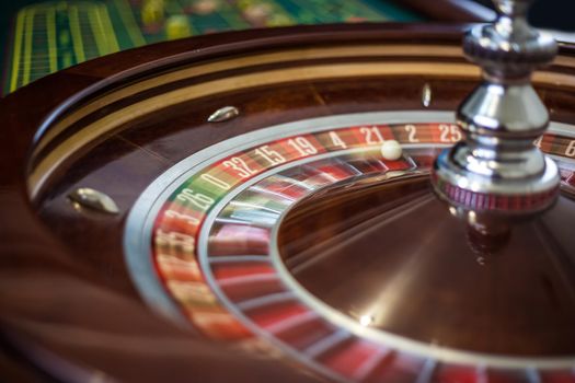 Classic casino roulette wheel with red sector twenty-one 21 and white ball. Close up