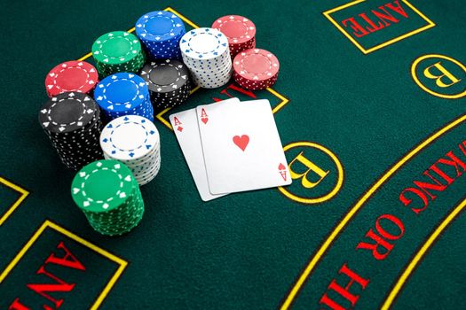 Poker play. Chips and cards on the green table