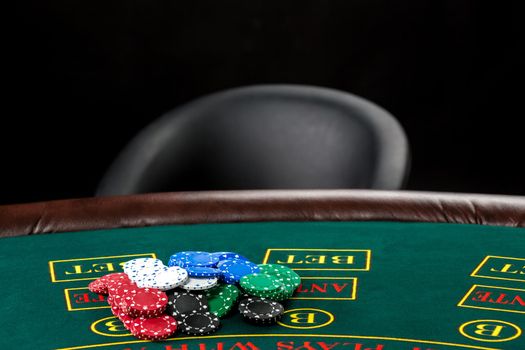 Poker play. Chips on the green table and empty chair