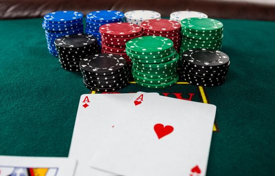 Poker play. Chips and cards on the green table