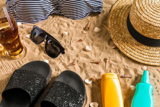 Summer bikini and accessories stylish beach set, Beach bikini summer outfit and sea sand as background, Top View, Concept. Copy space