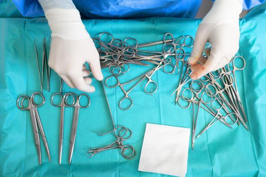 Multiple surgery instruments on blue table above view. surgeon take surgical tools from table. High quality photography.