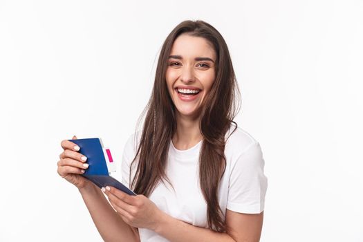 Travelling, holidays, summer concept. Close-up portrait of happy, charismatic pretty woman laughing, looking at her visa in passport with plane ticket, smiling joyful camera, ready for journey.