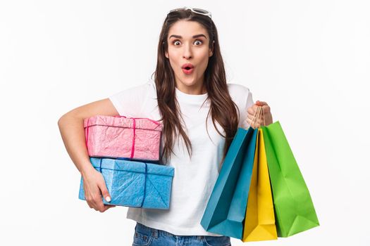 Shopping, holidays and lifestyle concept. Portrait of excited, amused young girl hurry up and buying presents, last days of promo offer discounts, holding gifts and shop bags.