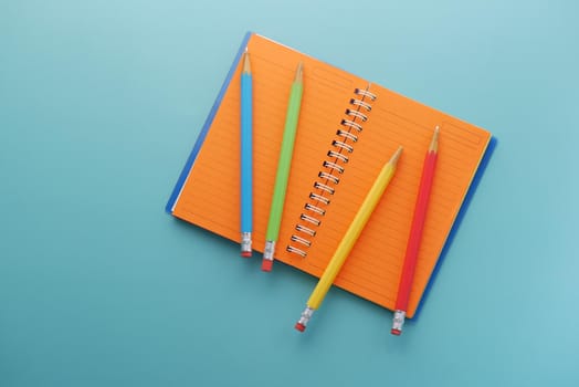 Close up of colorful pencils on notepad .