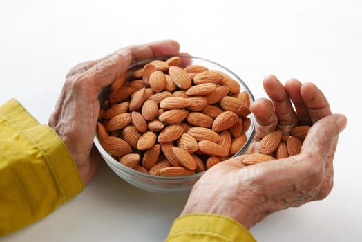 close up senior women hand holding a bowl on almond .