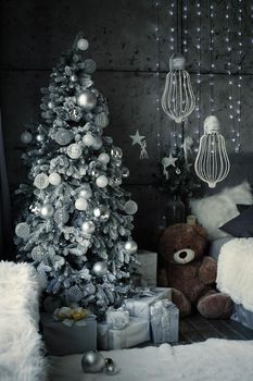 Christmas, New Year interior with gray wall background, decorated fir tree with garlands and balls, teddy bear and presents