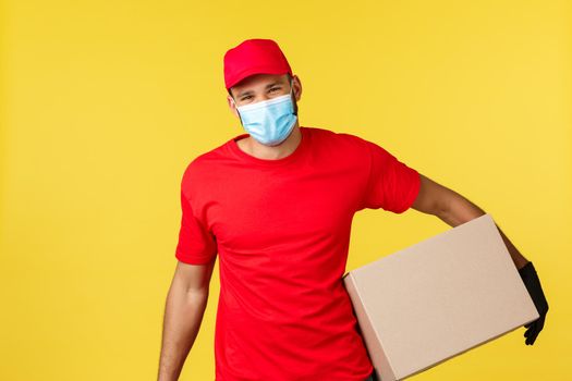 Express delivery during pandemic, covid-19, safe shipping, online shopping concept. Happy charismatic courier deliver order to your doorstep, smiling client, hold box wear medical mask and gloves.