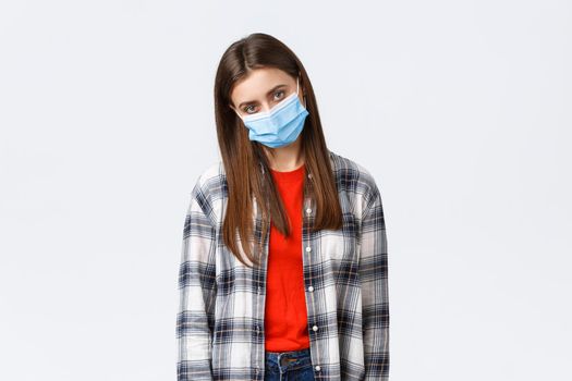 Coronavirus outbreak, leisure on quarantine, social distancing and emotions concept. Tired and bored young woman in medical mask complaining staying home self-isolation, want party and have fun.
