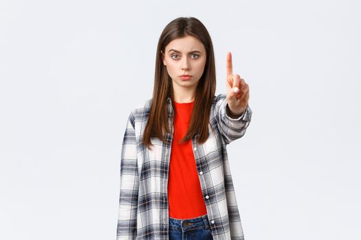 Lifestyle, different emotions, leisure activities concept. Serious concerned young woman showing index finger, scolding someone, tell to stop, warn or prohibit action, restrict from bad decision.