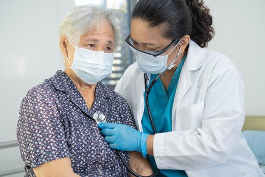 Asian doctor wearing face shield and PPE suit new normal to check patient protect safety infection Covid 19 Coronavirus outbreak at quarantine nursing hospital ward.