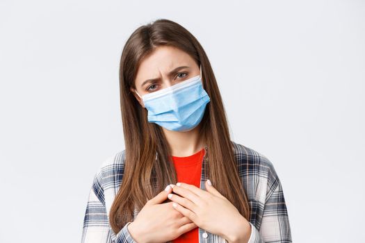 Coronavirus outbreak, leisure on quarantine, social distancing and emotions concept. Close-up of sick young woman in medical mask staying at home during covid-19, cough with closed eyes.