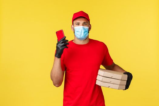 Food delivery, tracking orders, covid-19 and self-quarantine concept. Courier searching appartment of client, bring pizza order to doorstep, holding smartphone and boxes with takeaway.