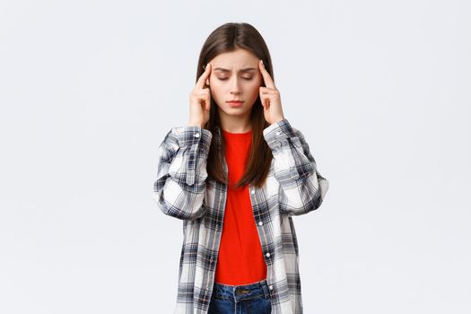 Lifestyle, different emotions, leisure activities concept. Distressed and exhausted young female student trying focus, feel headache or dizzy, close eyes and rub temples, white background.