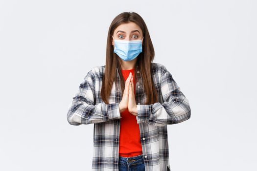 Different emotions, covid-19 pandemic, coronavirus self-quarantine and social distancing concept. Hopeful enthusisatic girl, volunteer in medical mask, asking please, begging help, hold hands in pray.