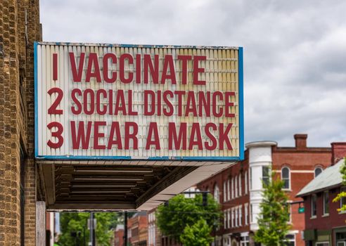 Mockup of movie cinema billboard with vaccinate, wear a mask, social distance to deal with the omicron variant of Covid-19 coronavirus epidemic