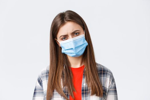 Coronavirus outbreak, leisure on quarantine, social distancing and emotions concept. Close-up of woman in medical mask feeling bad, catching disease or being tired after night shift.