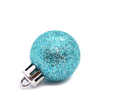 Blue glittering Christmas ornament ball on white background. Copy space on the right.