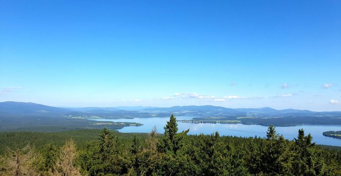 Aerial landscape view of Lipno dam and the forest with clear blue sky. South Bohemia, Czech Republic. 