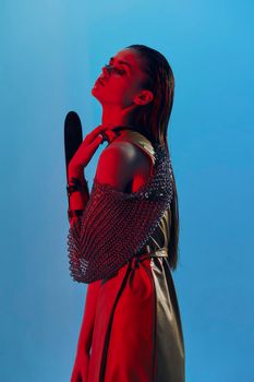 young woman Glamor posing red light metal armor on hand Lifestyle unaltered. High quality photo